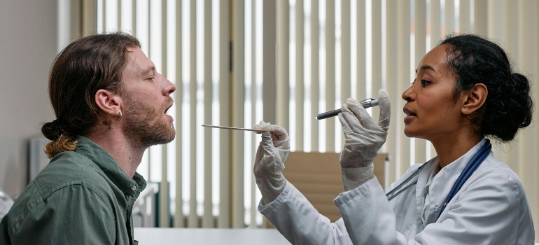 Doctor performing a checkup, showing typical healthcare services that impact living expenses.