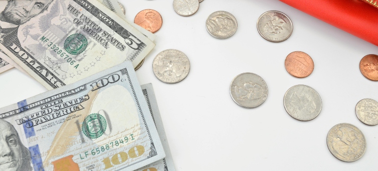US dollars and coins on a table representing everyday spending tied to the cost of living in Austin TX.
